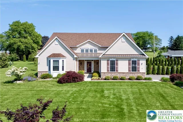 a front view of a house with a yard and trees
