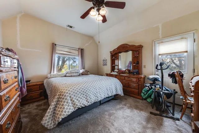 a bedroom with a bed and a flat tv screen on dresser