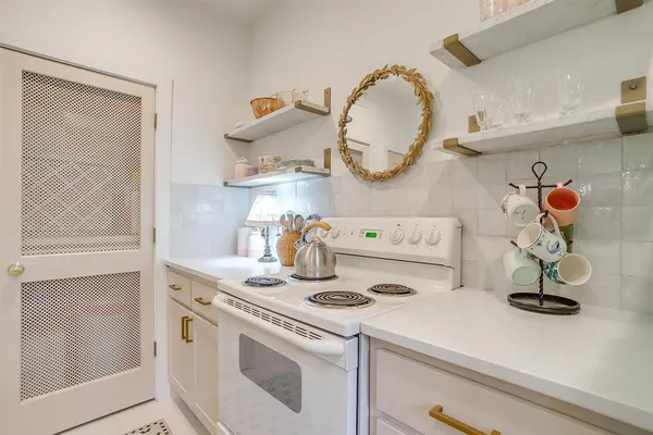 a kitchen with a stove and a wooden floor