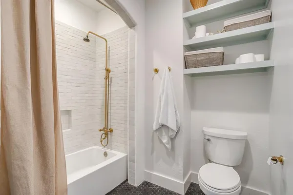 a white toilet sitting next to a bathtub