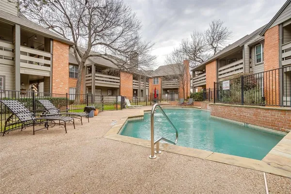 a view of a swimming pool with a bench and a fire pit