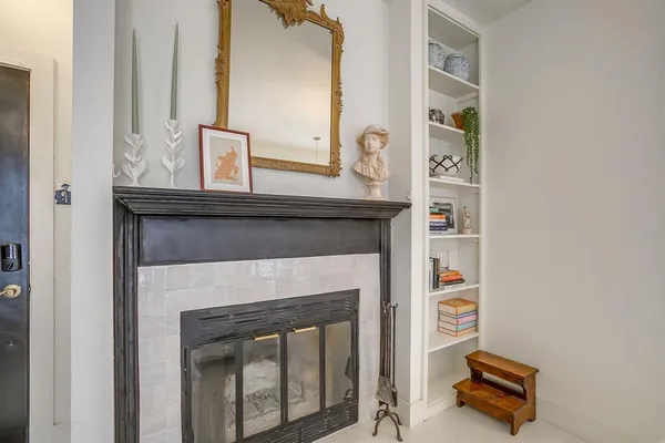 a room with a fireplace and mirror