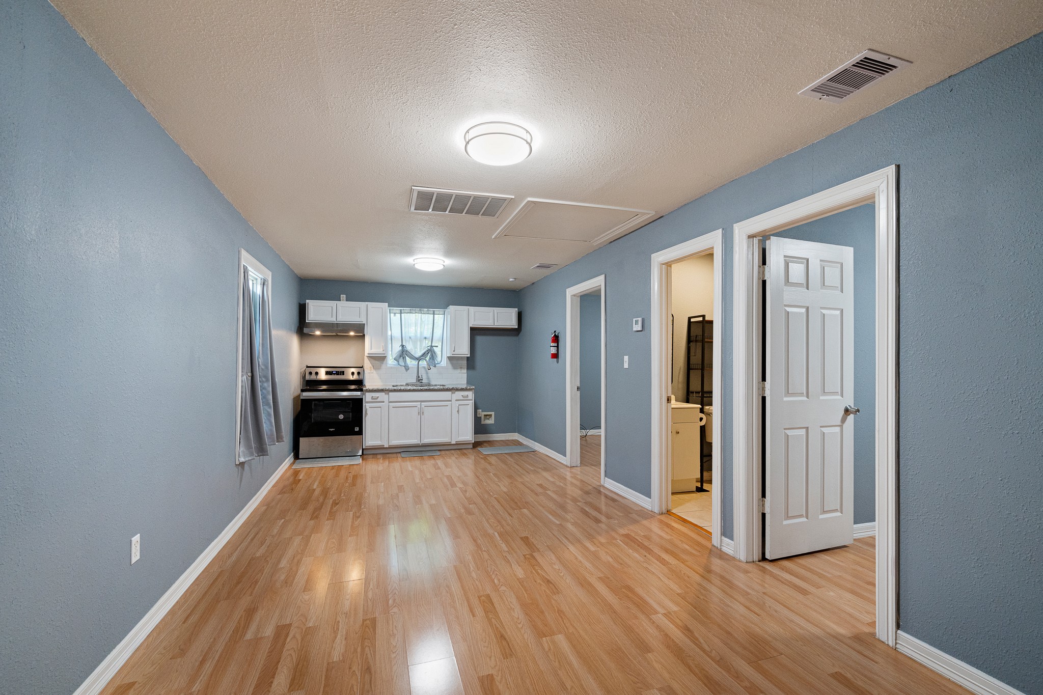 7815 Harding Street, Unit B Houston, TX 77012 - Photo 6 of 21 Experience seamless living with this inviting space that effortlessly blends the cozy living room into a functional kitchen/dining combo, enhanced by sleek flooring and modern fixtures.