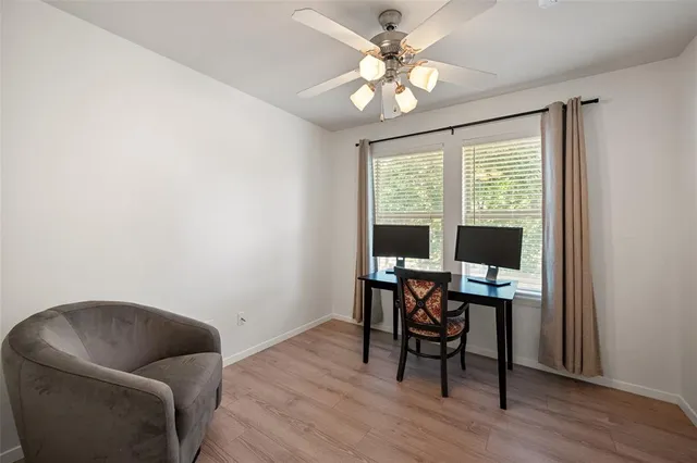 a view of a workspace with furniture and a window