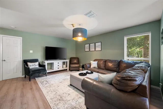 a living room with furniture a flat screen tv and a large window