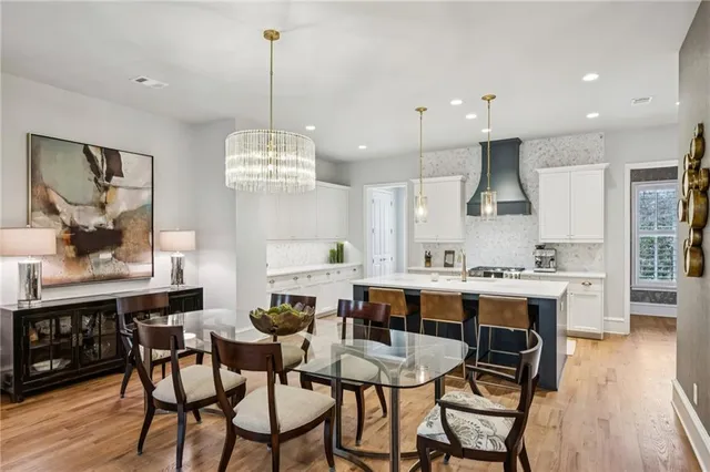 a view of a dining room and livingroom with furniture wooden floor a chandelier