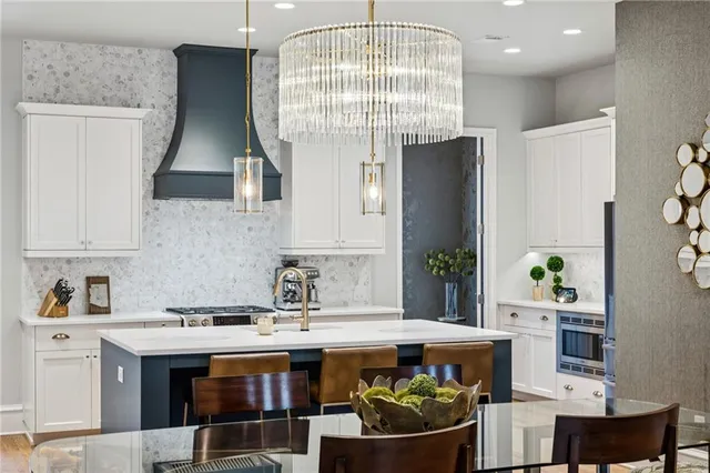 a kitchen with a dining table chairs sink and white cabinets