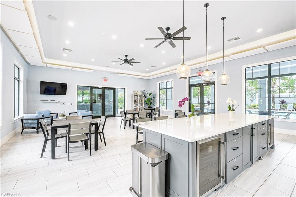 2620 Seychelles Circle, Unit 1302 Naples, FL 34112 - Photo 41 of 43 a large kitchen with kitchen island a sink dining table and chairs