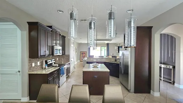 a kitchen with stainless steel appliances kitchen island granite countertop a refrigerator and a stove