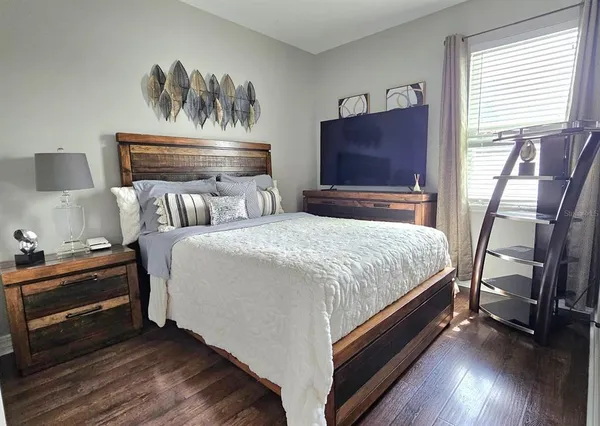 a bedroom with a bed and wooden floor