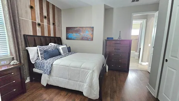 a bedroom with a bed and wooden floor