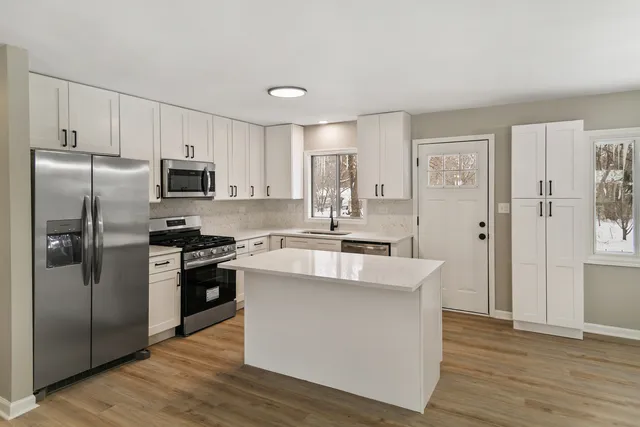 a kitchen with stainless steel appliances a refrigerator stove and sink