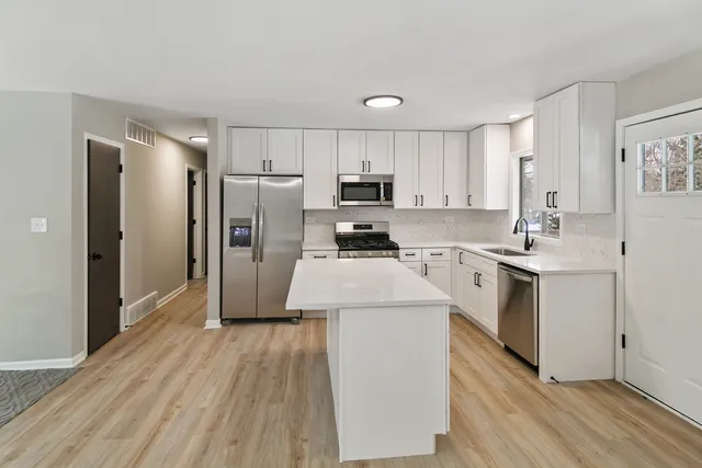 a kitchen with a refrigerator sink and cabinets