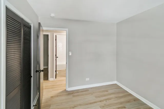 an empty room with wooden floor and a window