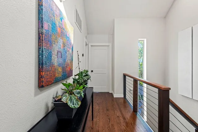 a view of a hallway with wooden floor and glass door