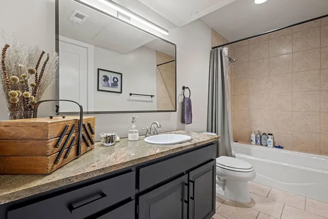a bathroom with a granite countertop sink a toilet and a bathtub