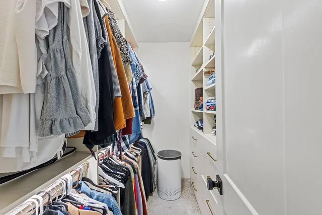 a view of walk in closet with clothes