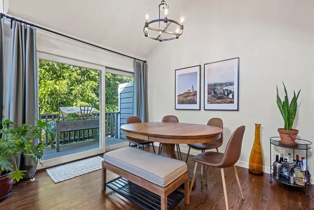 a dining room with furniture a large window and wooden floor
