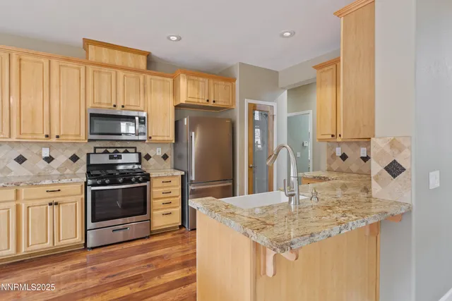 a kitchen with stainless steel appliances granite countertop a stove refrigerator and microwave
