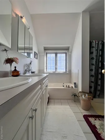 a bathroom with a tub sink and mirror
