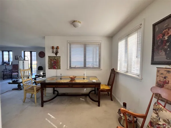 a room with table chair and windows