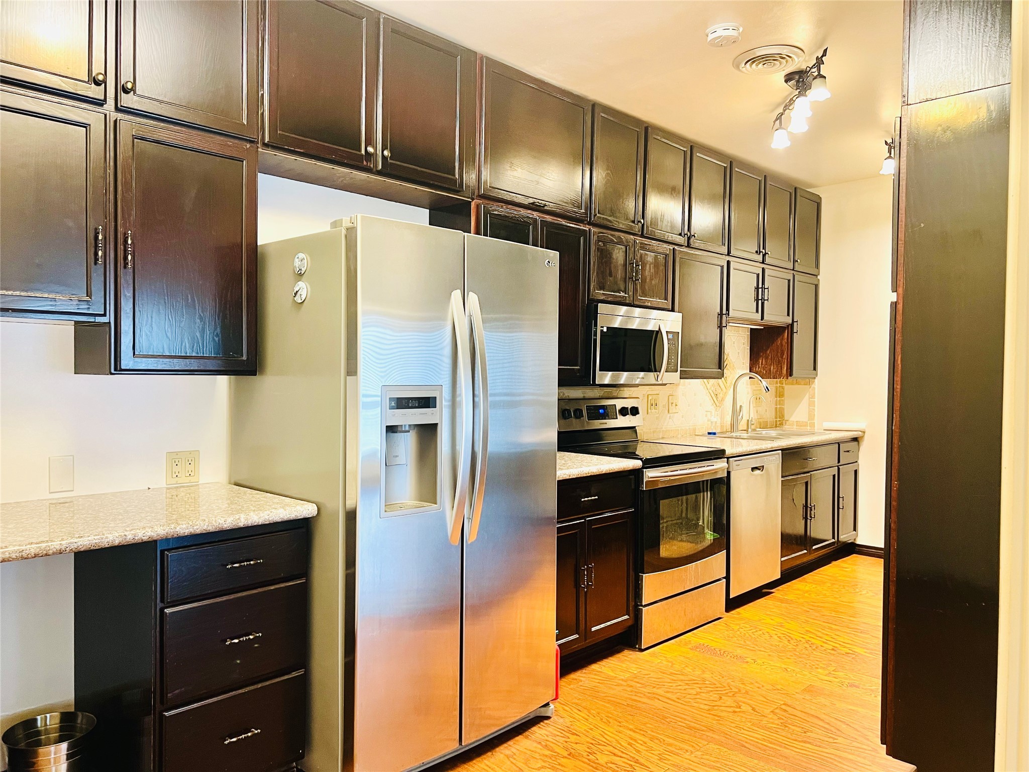 2100 Tanglewilde Street, Unit 536 Houston, TX 77063 - Photo 17 of 37 a kitchen with stainless steel appliances granite countertop a refrigerator and a sink