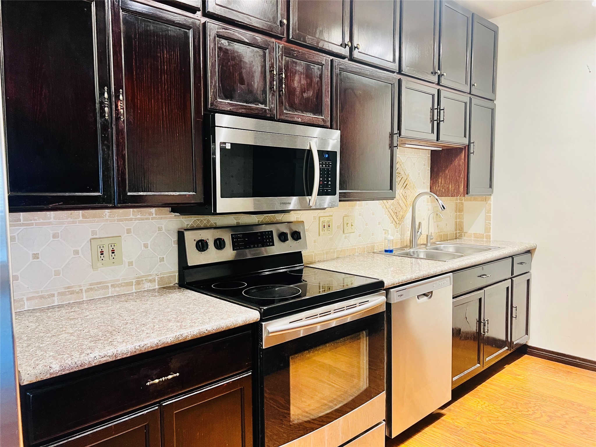 2100 Tanglewilde Street, Unit 536 Houston, TX 77063 - Photo 19 of 37 a kitchen with stainless steel appliances a stove sink and microwave