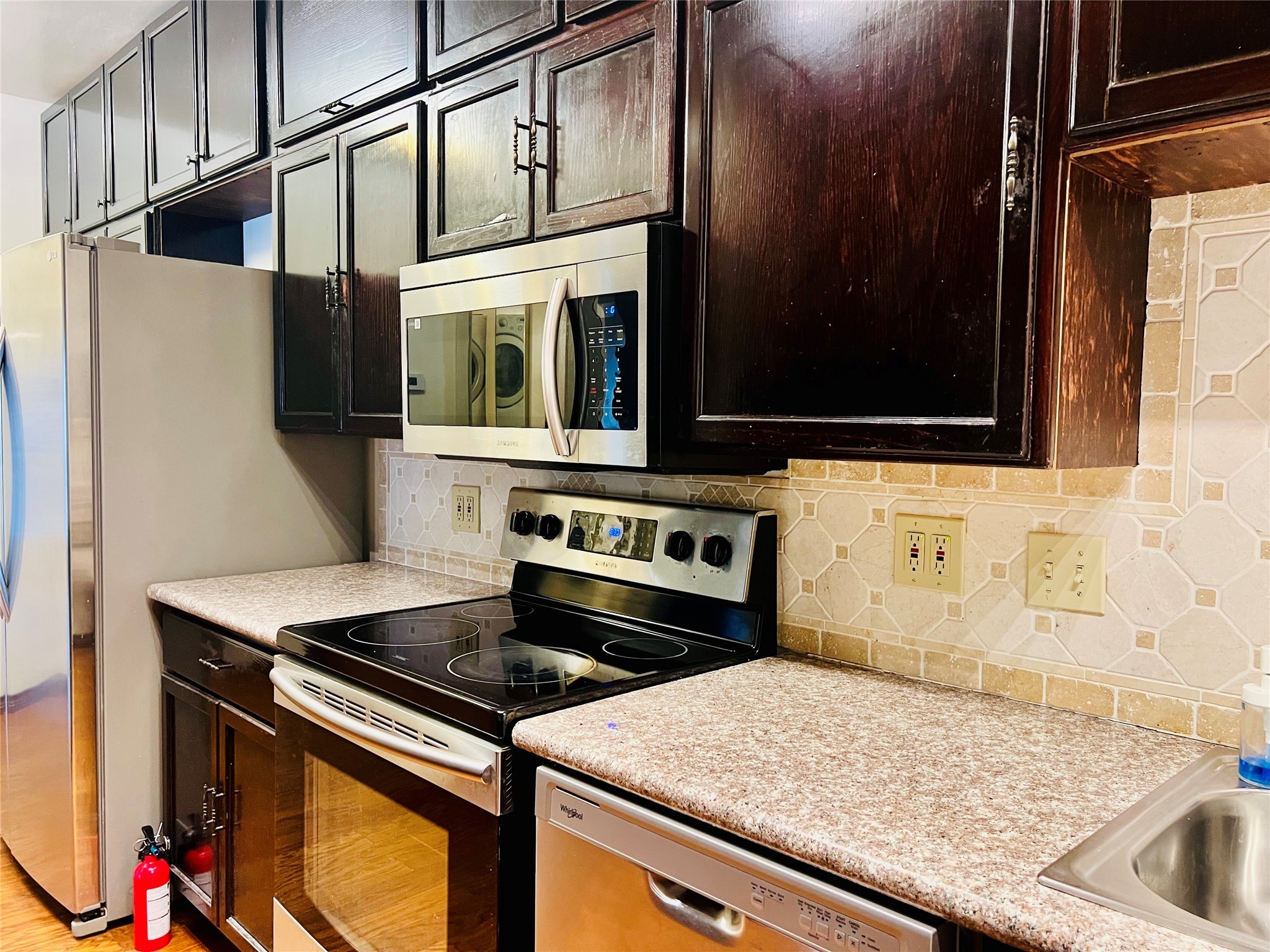 2100 Tanglewilde Street, Unit 536 Houston, TX 77063 - Photo 23 of 37 a kitchen with stainless steel appliances granite countertop a stove and a microwave