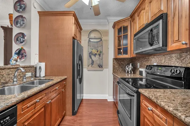 a kitchen with stainless steel appliances granite countertop a sink stove and refrigerator