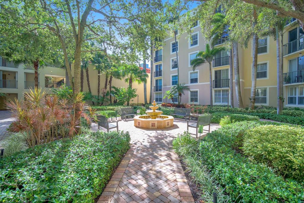 630 South Sapodilla Avenue, Unit 407 West Palm Beach, FL 33401 - Photo 19 of 25 a view of a patio with couches table and chairs and potted plants and large trees