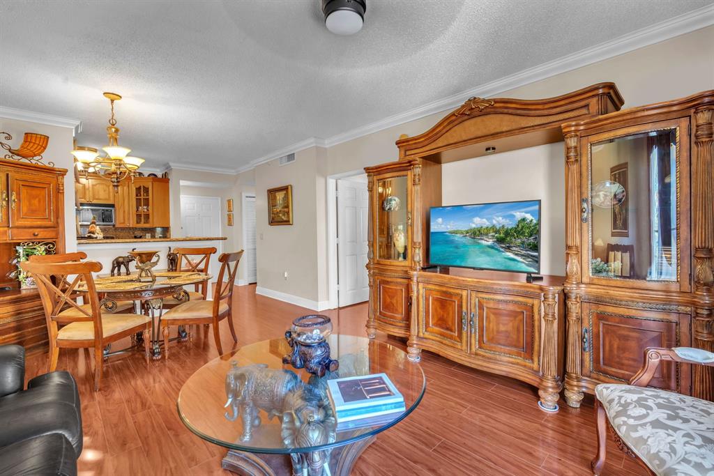 630 South Sapodilla Avenue, Unit 407 West Palm Beach, FL 33401 - Photo 7 of 25 a living room with furniture a fireplace and a dining table with wooden floor