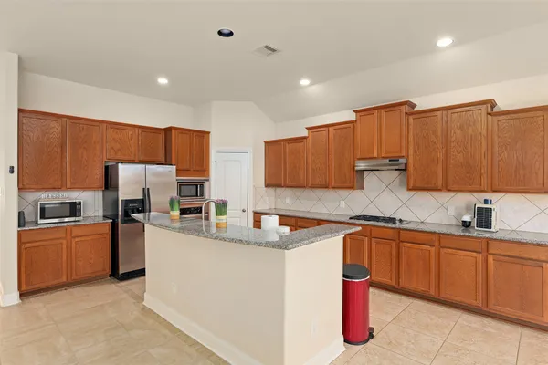 a kitchen with stainless steel appliances granite countertop a sink stove and refrigerator