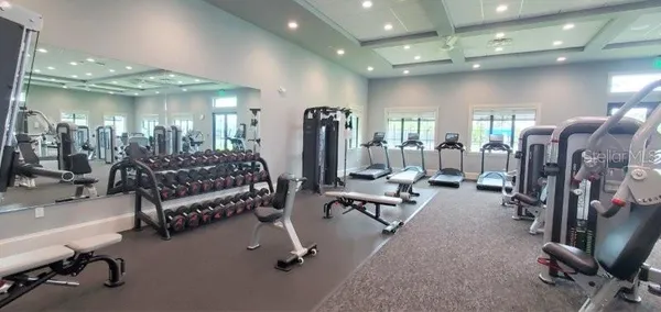 a living room with furniture a large mirror and gym equipment