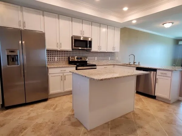 a kitchen with stainless steel appliances granite countertop a refrigerator and a sink