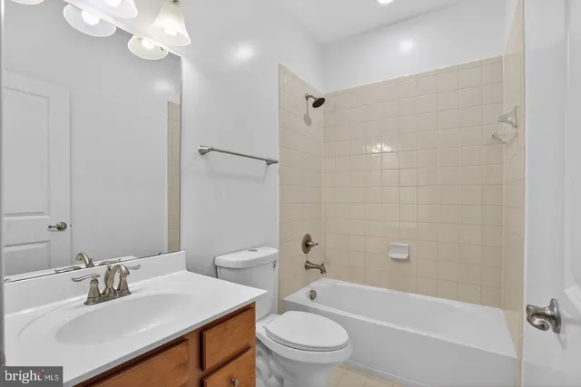 a bathroom with a sink a toilet a mirror a bathtub and shower