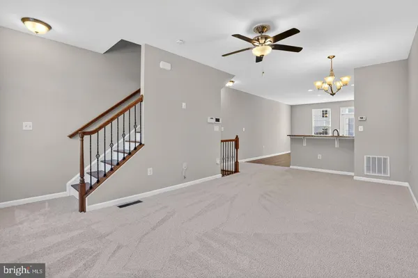 a view of an empty room with a ceiling fan and window