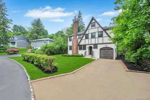 a front view of a house with a yard and potted plants