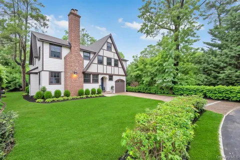 a front view of a house with a yard and trees