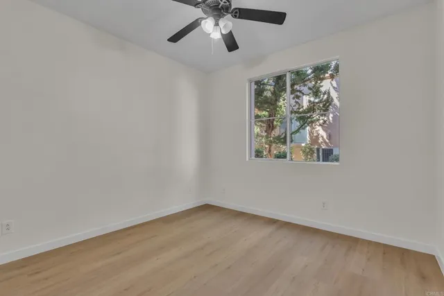an empty room with a window and a fan