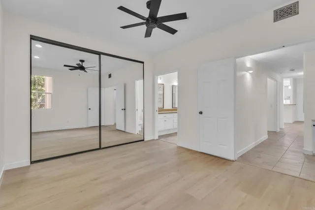 a view of a big room with a chandelier fan and windows