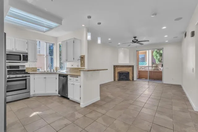 a kitchen with granite countertop a stove top oven and cabinets