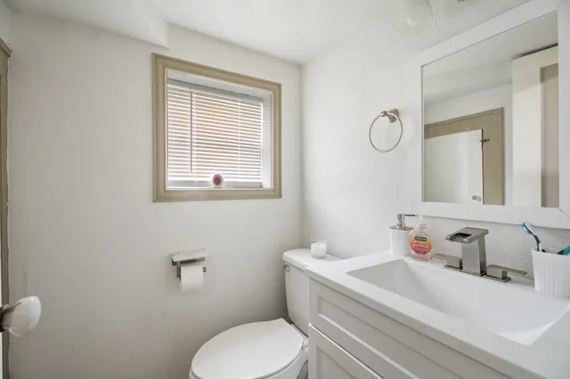 a bathroom with a sink toilet and a mirror