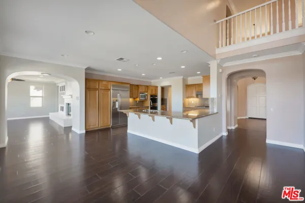 a kitchen with stainless steel appliances a large counter top a sink and a wooden floors