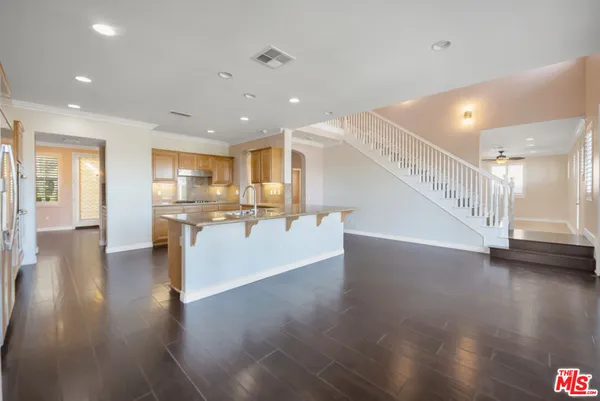 a large kitchen with stainless steel appliances granite countertop a large window and a refrigerator