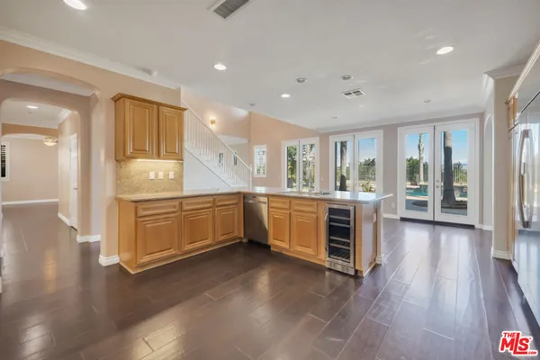 an empty room with wooden floor fireplace and windows