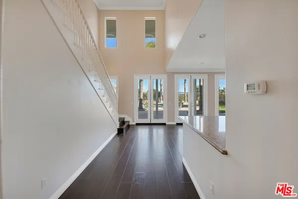 a view of a living room and kitchen with stainless steel appliances wooden floor