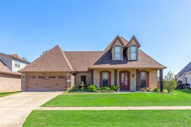 a front view of a house with a garden and yard