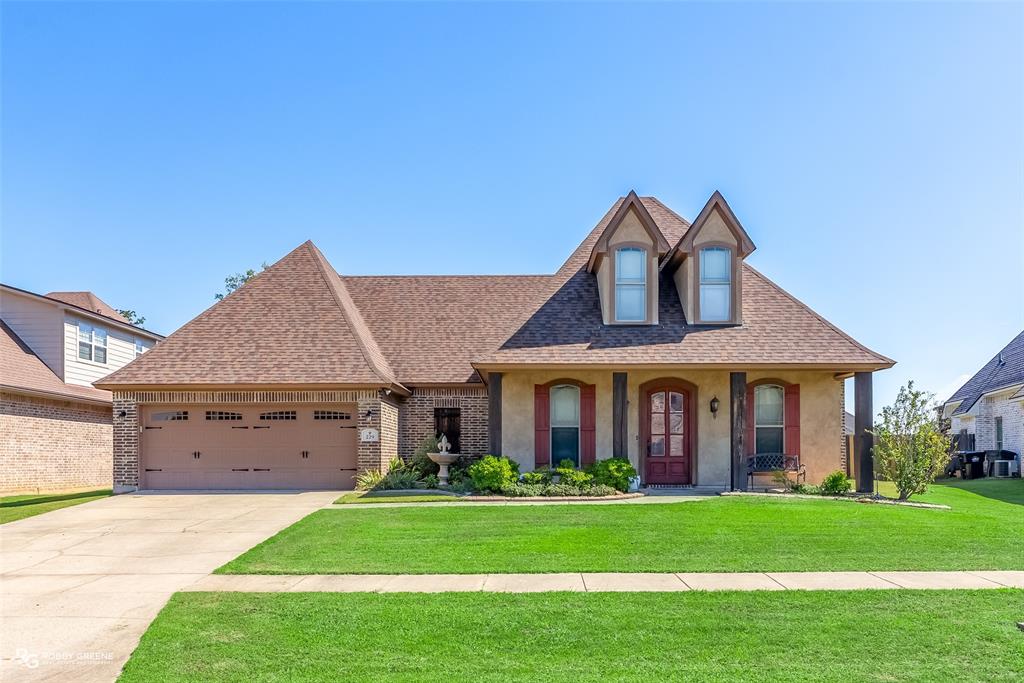 a front view of a house with a garden and yard