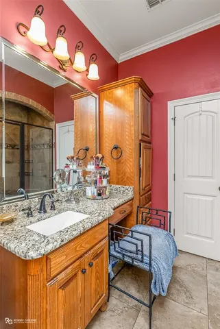 a bedroom with a large bed and a chandelier