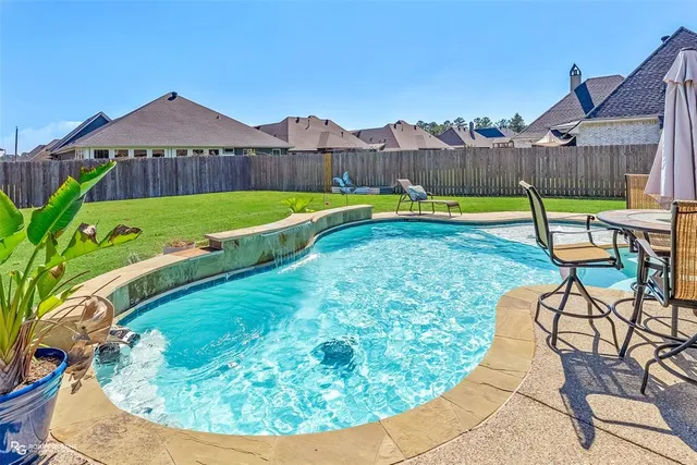 an aerial view of a house with swimming pool and patio